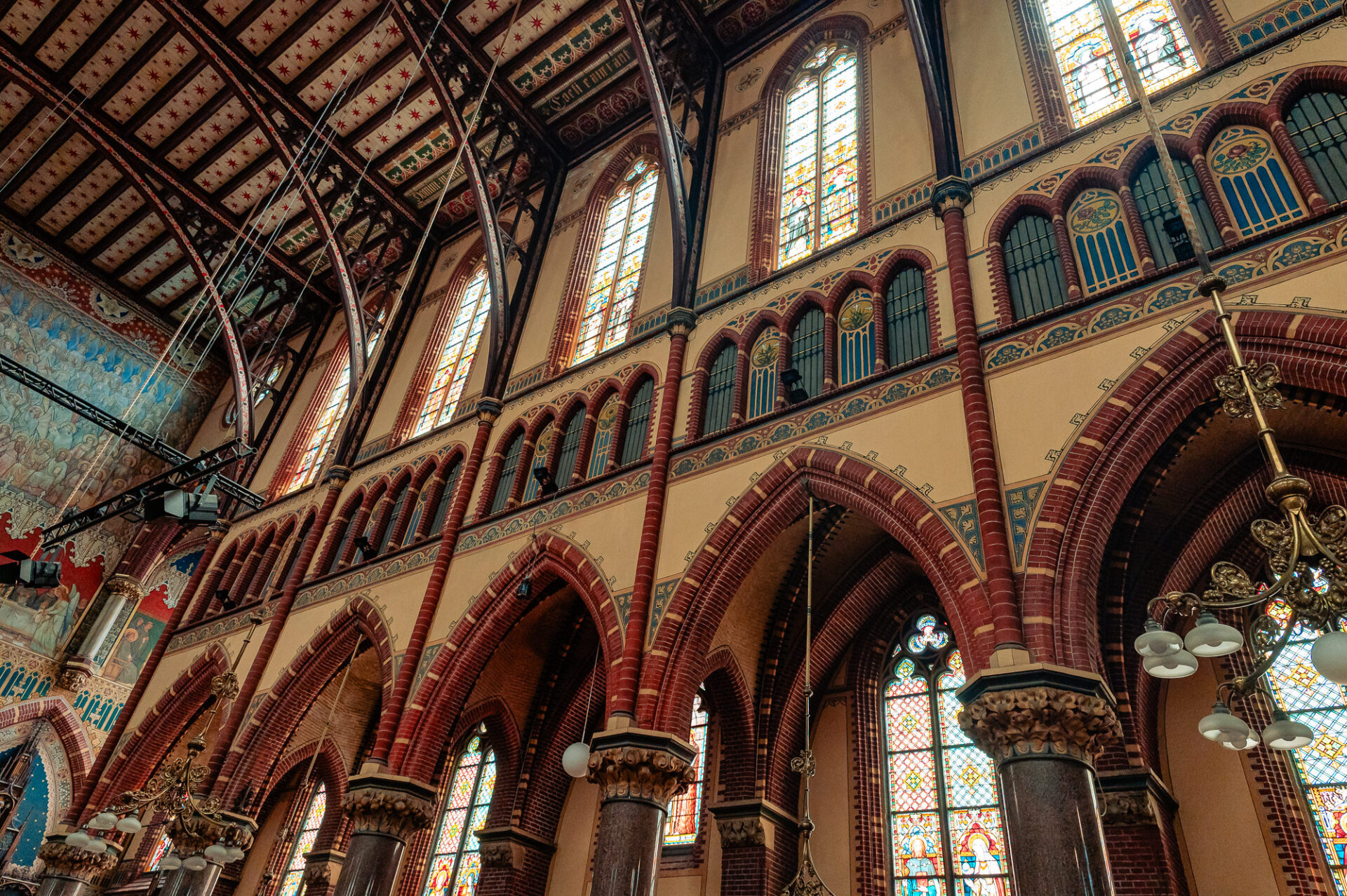 Detailed Gothic Revival architecture and stained glass windows inside a historic Amsterdam church