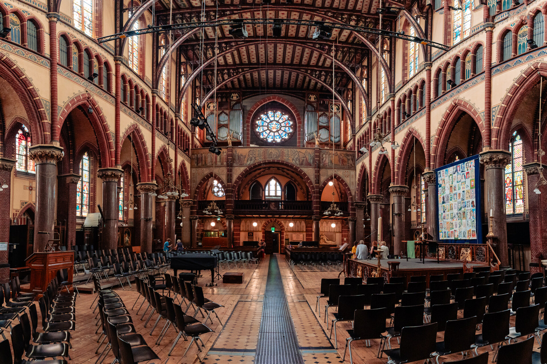 Grand interior of a historic Amsterdam church with brick arches, stained glass and ornate details