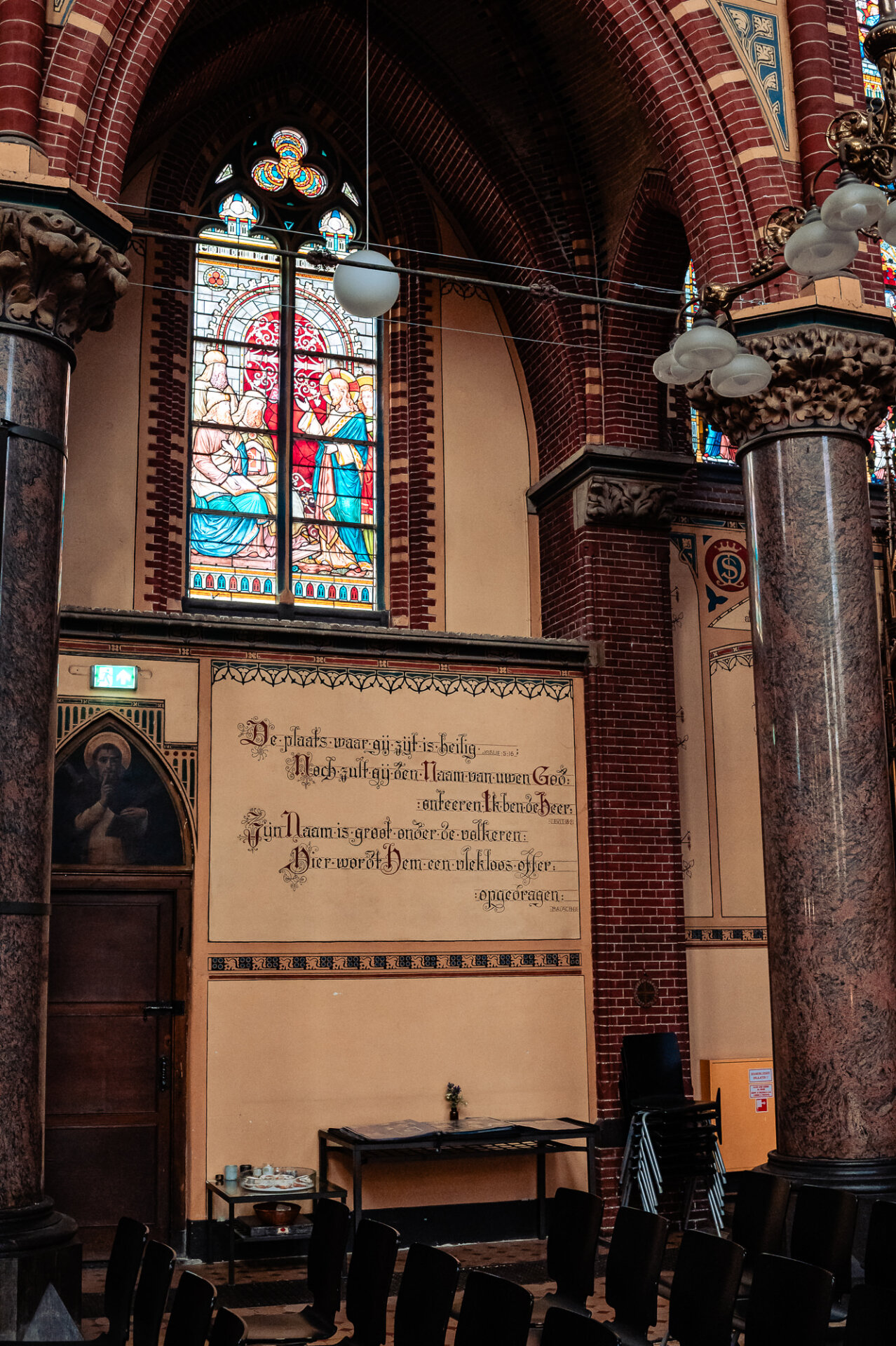 Stained glass window and decorative brick arches inside a historic Amsterdam church