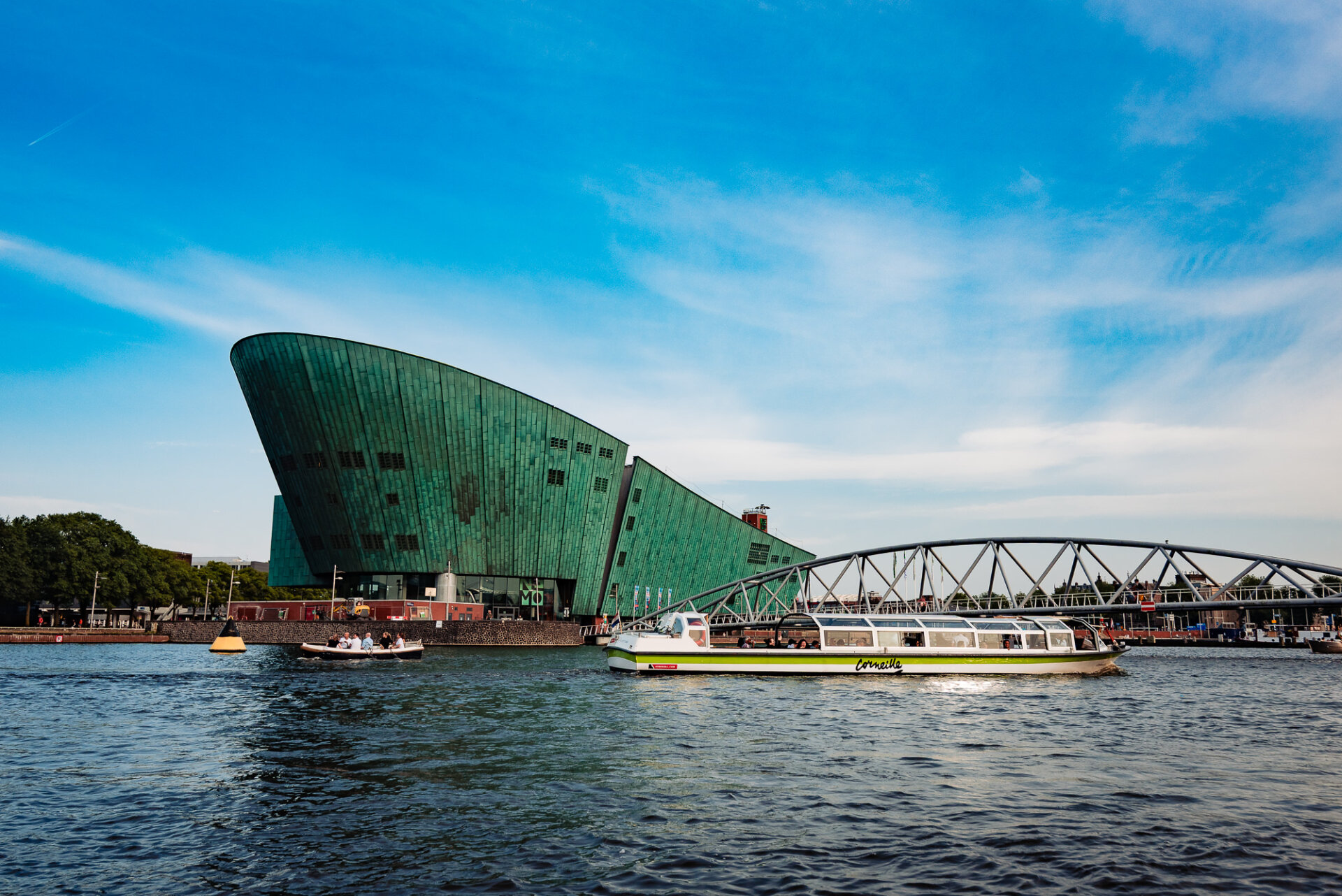 Canal cruise boat passing the modern NEMO Science Museum along Amsterdam’s waterfront