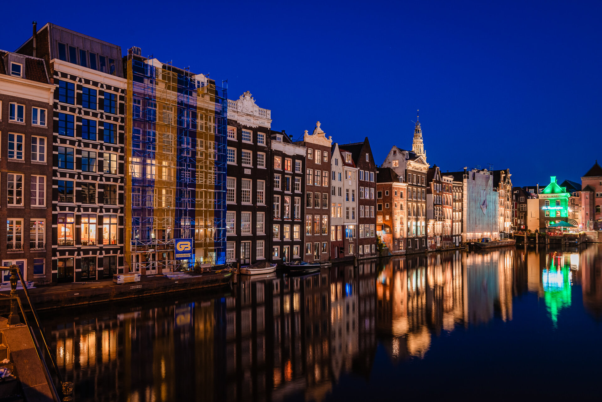 275. Historic Amsterdam canal houses illuminated at night with colourful reflections across the water