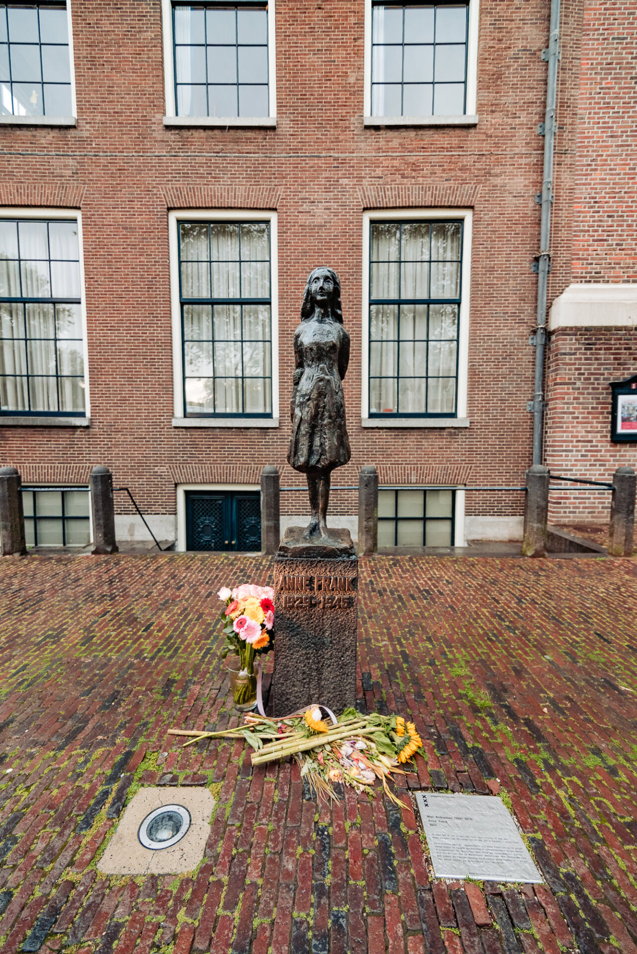 317. Anne Frank statue with flowers and tributes outside the Westerkerk in Amsterdam