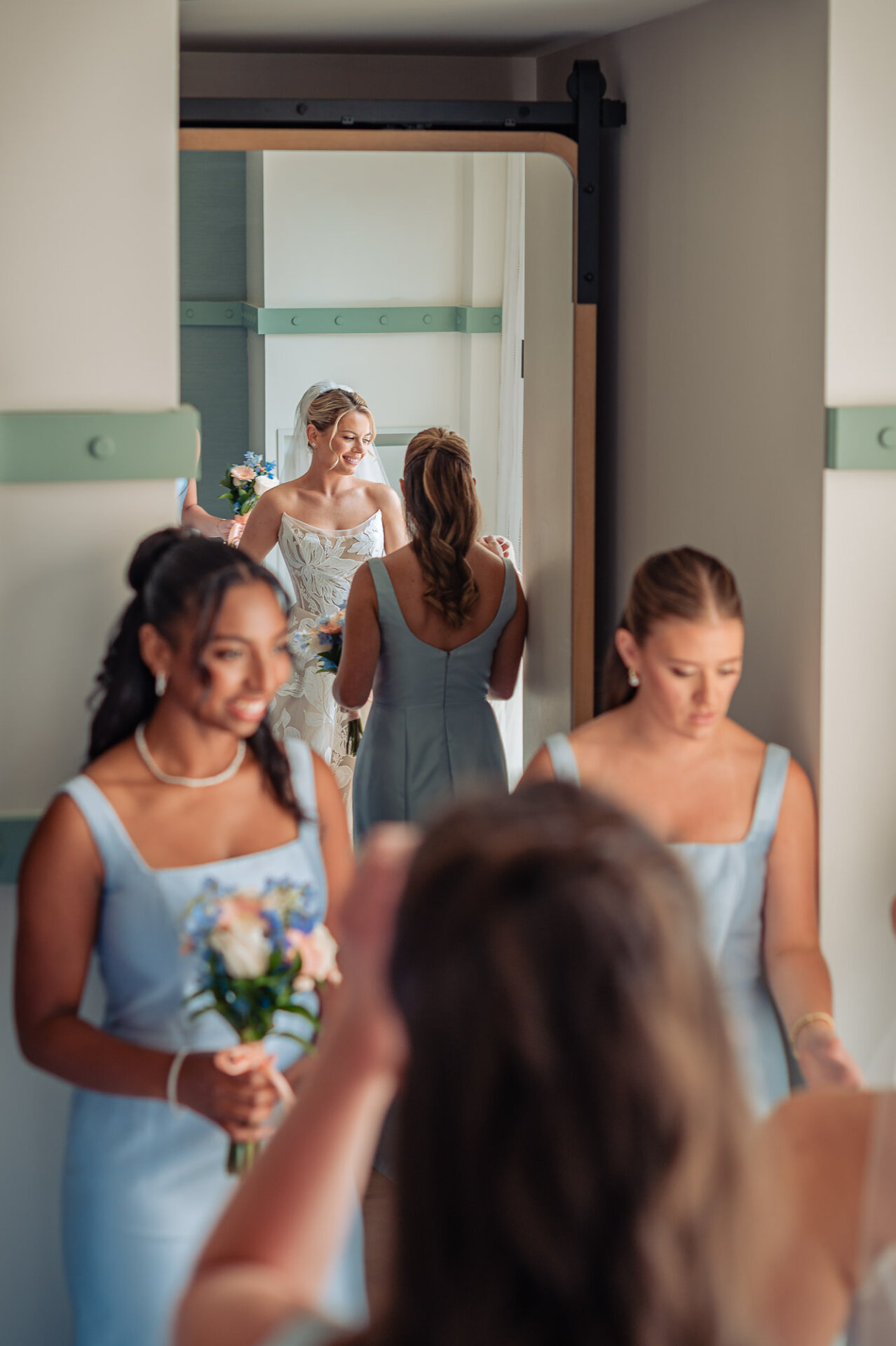 Bride greets her bridesmaids in light blue dresses before the wedding at The Ben Philadelphia.