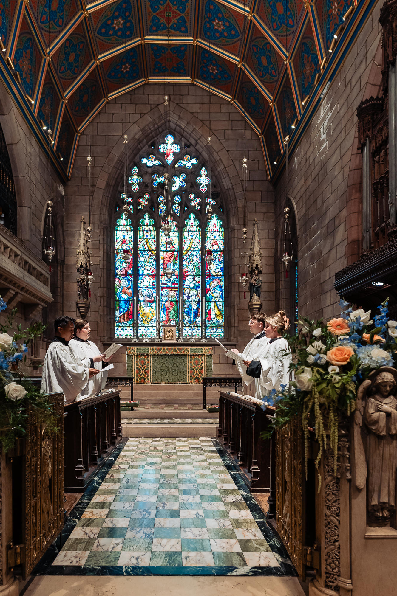 Church choir members perform beneath stained-glass windows during the Philadelphia wedding ceremony.