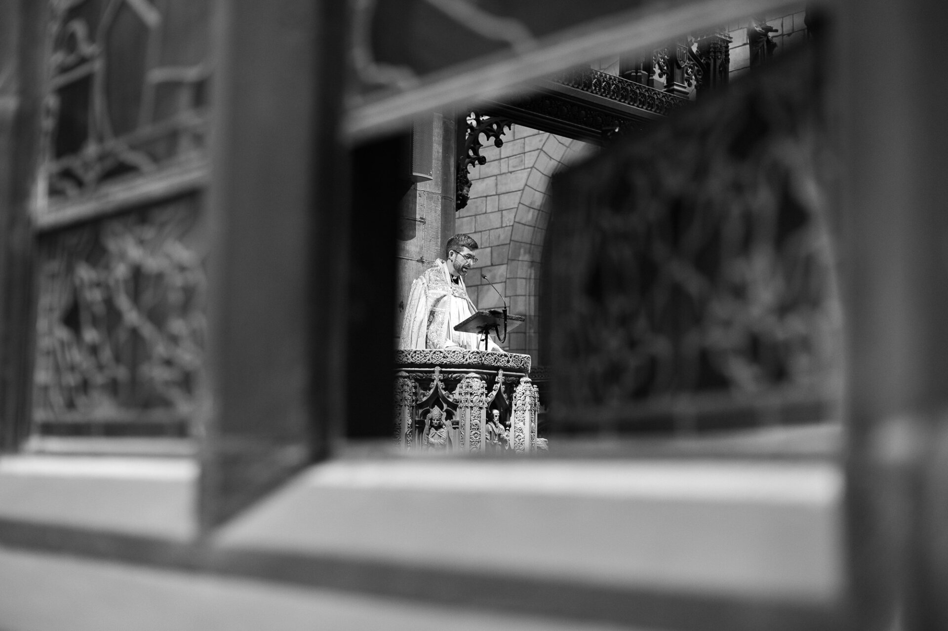 Priest speaking from an ornate church pulpit during the wedding ceremony.