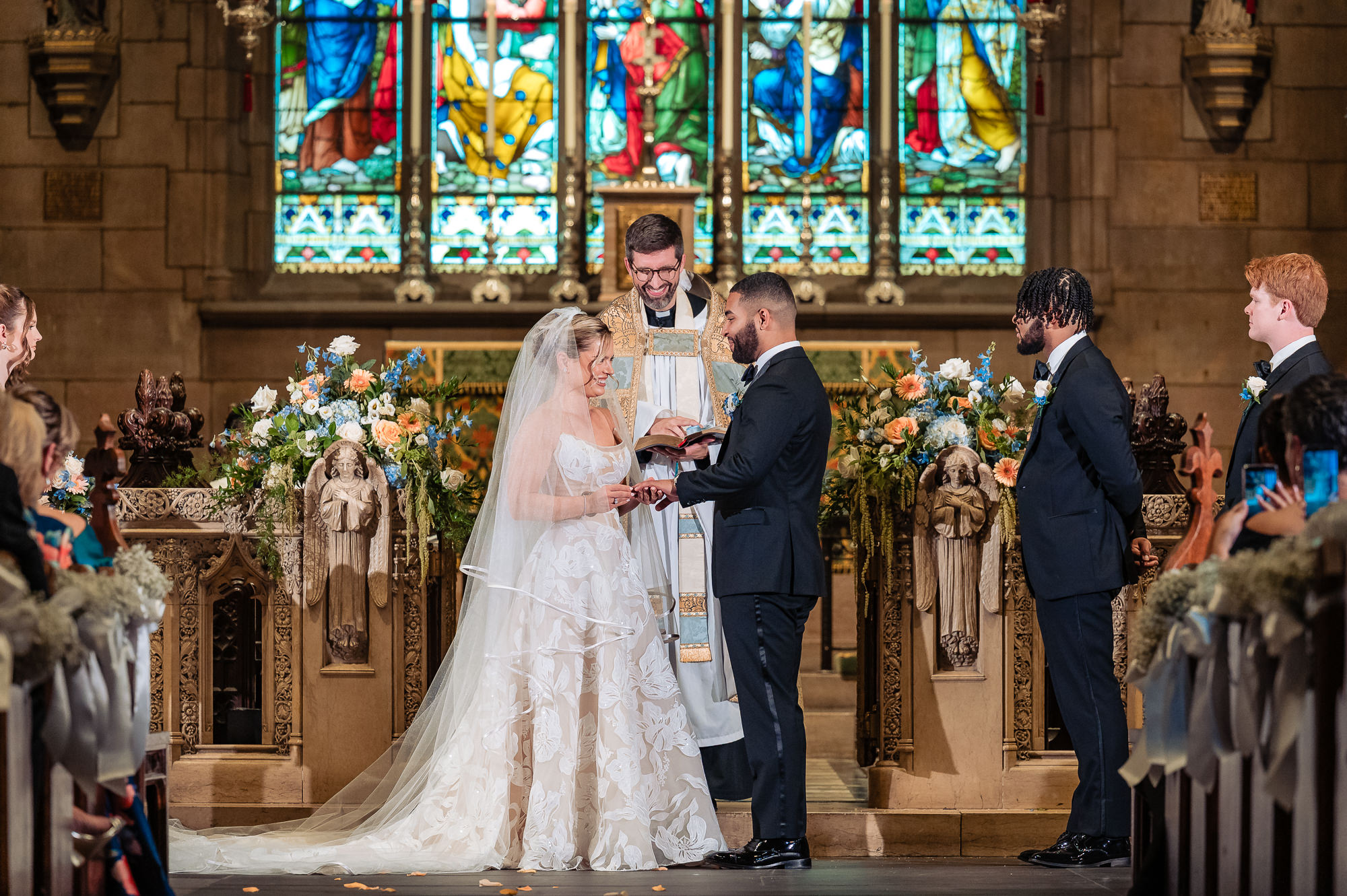 Bride placing a ring on the groom’s finger at the altar.
