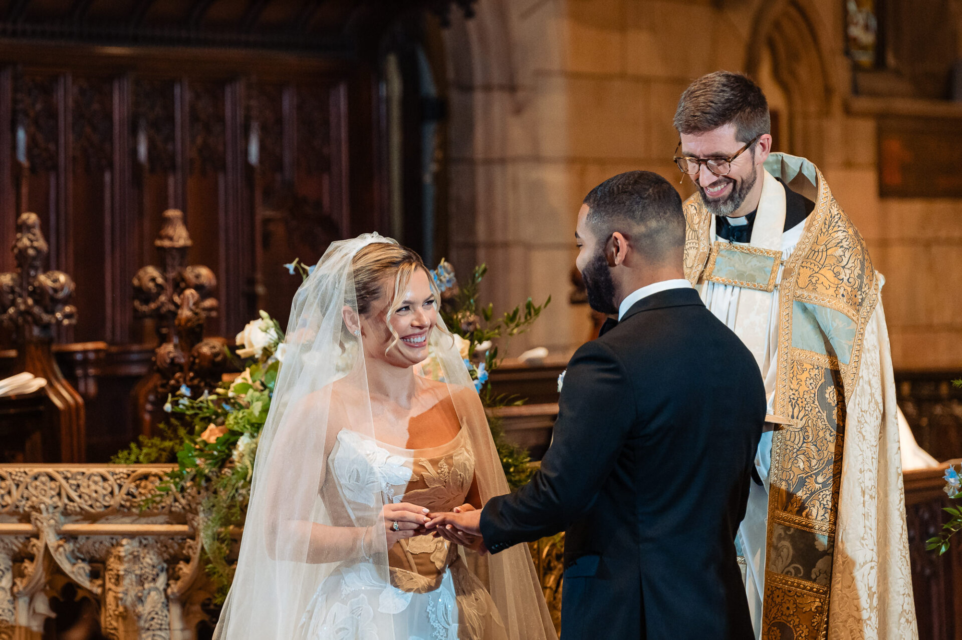 Bride and groom exchange rings during their Philadelphia church wedding ceremony.