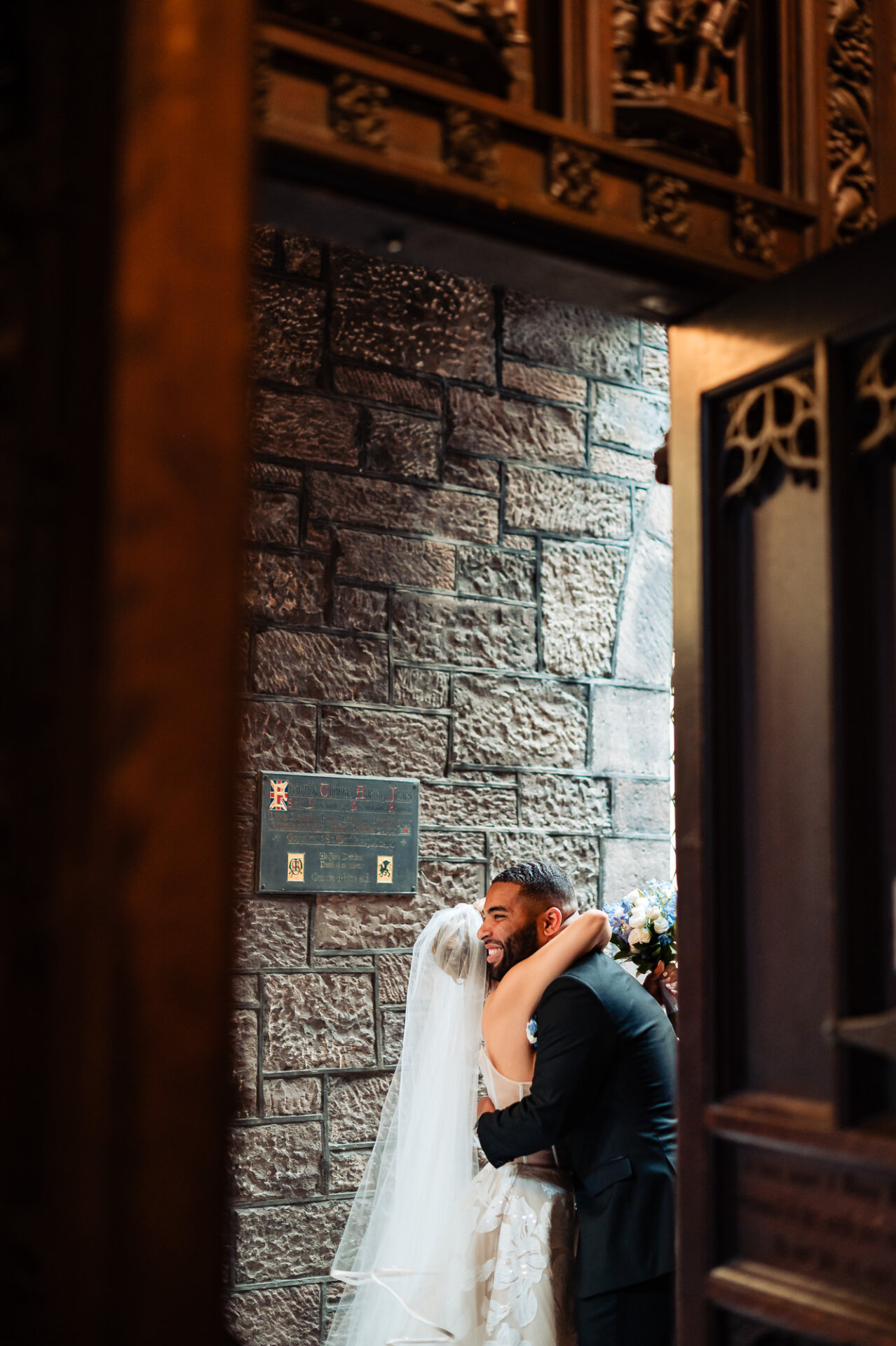 Bride embraces the smiling groom in the church doorway after their Philadelphia wedding ceremony.