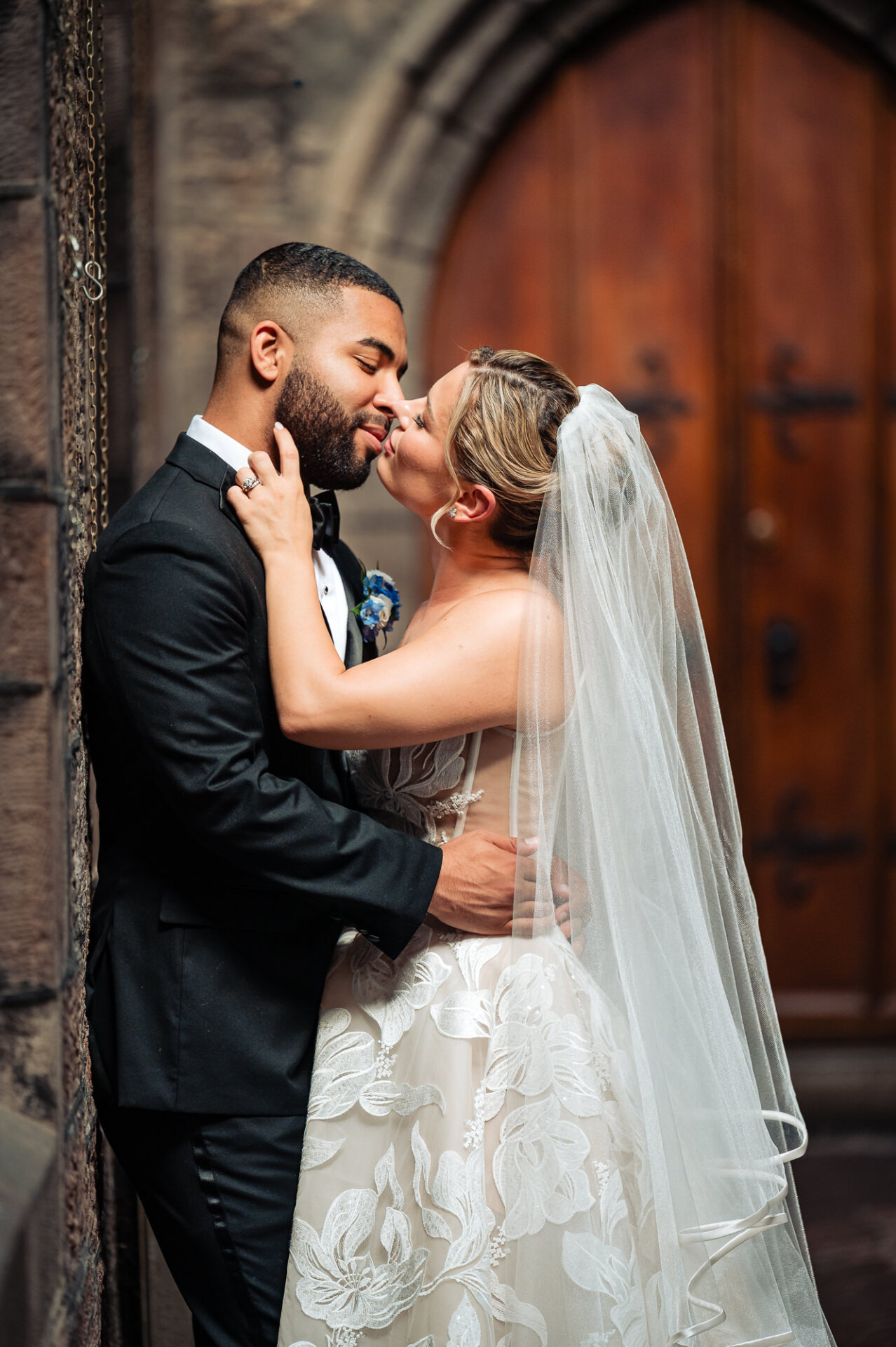 Bride kisses the groom outside Saint Mark’s Church during their Philadelphia wedding.
