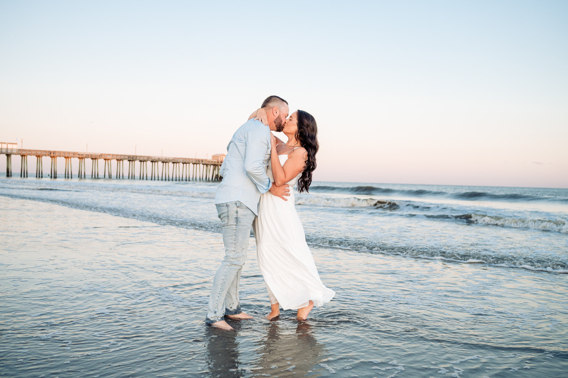 Couple sharing a romantic kiss while standing barefoot in the shallow waves at Margate Beach, New Jersey