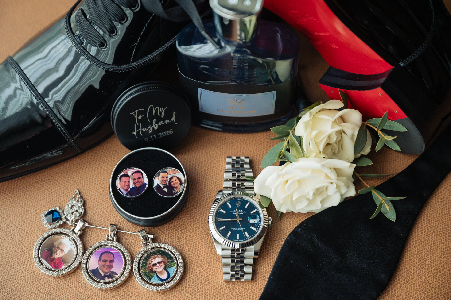 Groom details flat lay featuring black Christian Louboutin shoes, Rolex watch, custom photo cufflinks, and cologne
